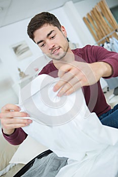 Man packing clothes into travel bag