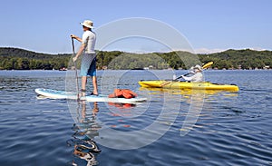 Man on Paddleboard Woman on Kayak photo