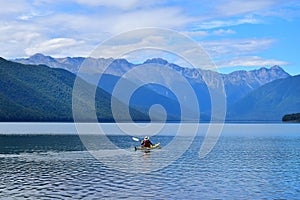 A man paddling across Lake Rotoroa in the Nelson Lakes National Park, New Zealand, South Island