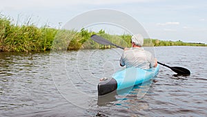 Man paddling in a blue kayak