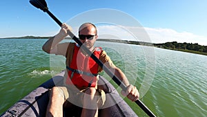 Man paddling in inflatable kayak on Vransko lake in Croatia.