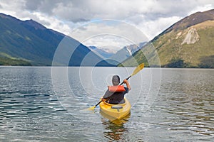 Man paddling kayak in mountain lake