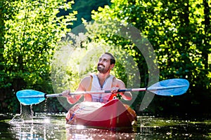 Man paddling with kayak on river for water sport