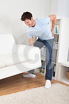 Man in pain lifting couch