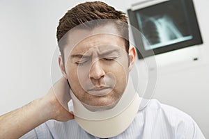 Man In Pain Wearing Neck Brace photo
