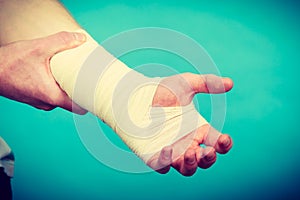 Man with painful bandaged hand.