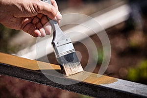 Man is painting a metal railing with copper varnish