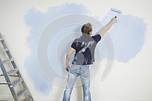 Man Painting Wall With Paintroller photo