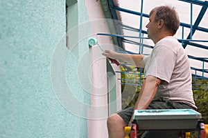 Man painting wall with a roll