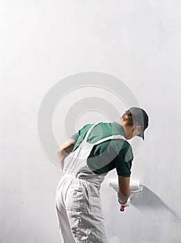Man painting a wall in white color