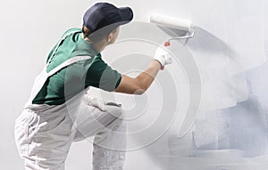 Man painting a wall in white color