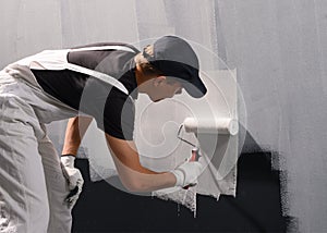 Man painting a wall in white color