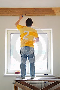 Man Painting a Exposed Beams