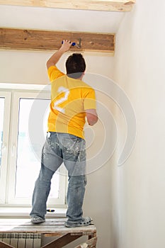 Man Painting a Exposed Beams