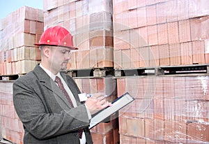 A man with pallets of bricks