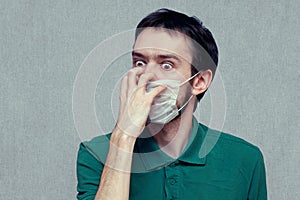 Man in panic trying tear off a medical mask. virus mutation, panic, paranoia