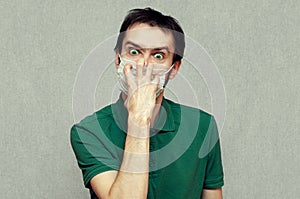 Man in panic trying tear off a medical mask. virus mutation, panic, paranoia