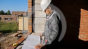Man with paper draft in building under construction