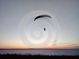 A man on a parachute descends over the Volga River, Russia