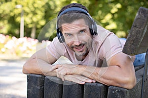 man on park bench wearing headphones