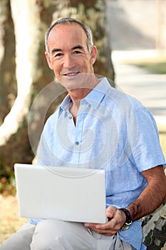 Man in park with laptop
