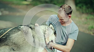 A man in park stroking a dog