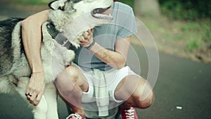 A man in park stroking a dog