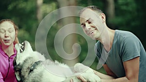 A man in park stroking a dog