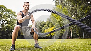 Man in park using battle rope