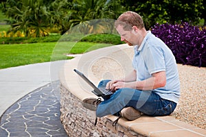 Man in park using laptop computer