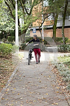 Man in park walking with electric bicycle