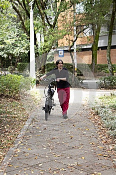 Man in park walking with electric bicycle