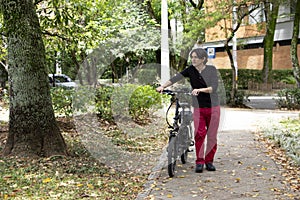 Man in park walking with electric bicycle