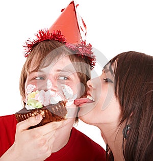 Man in party hat and girl eating cake.