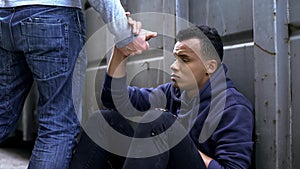 Man passing by, offering helping hand to street child, kindness and charity photo