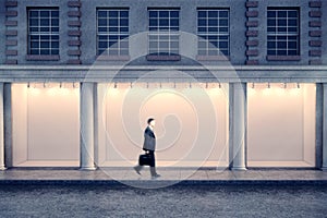 Man passing storefront at night photo