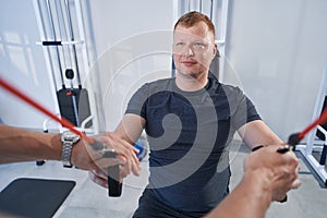 Man patient doing exercises of ligament sprain in physiotherapy clinic
