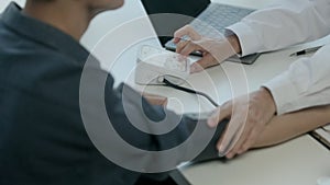 Man patient sitting in examining room having blood pressure checked by doctor