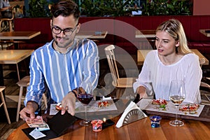 Man paying the bill after dinner with his girlfriend.