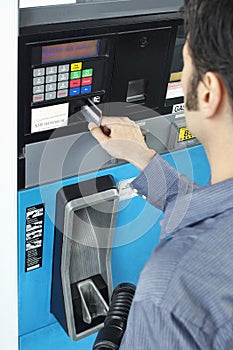Man Paying With Credit Card At Fuel Pump