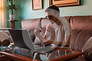 Man paying with credit card on laptop at home