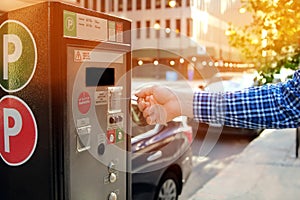 Man is paying his parking using credit card at parking pay station terminal.