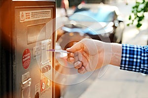 Man is paying his parking using credit card at parking pay station terminal.