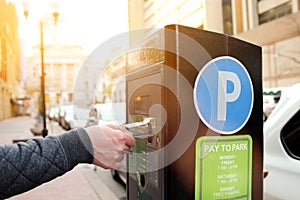 Man is paying his parking using credit card at parking pay station terminal.