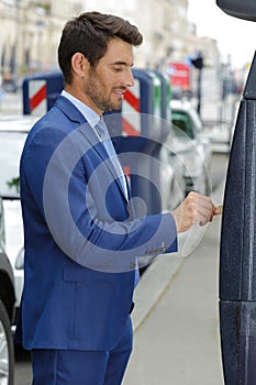man paying for parking ticket on machine