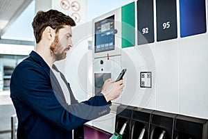 Man paying with phone at the gas station