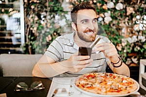 Man paying for pizza using credit card and mobile phone. Modern payment systems concept