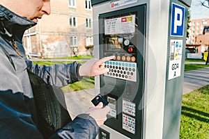 Man pays for parking with a credit card with NFS technology. Easy payment. Process of paying in machine parking terminal. Payment