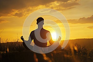 Man Peacefully Meditating In A Serene Yoga Pose During Golden Sunset