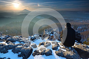 Man on peak above of freeze hilly landscape rocks c